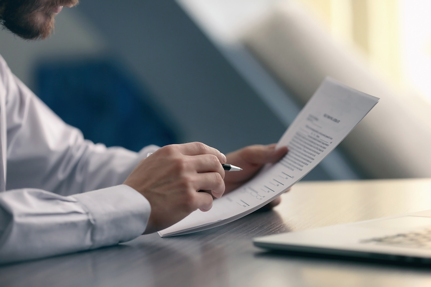 A business man reading a configuration management (CM) whitepaper.